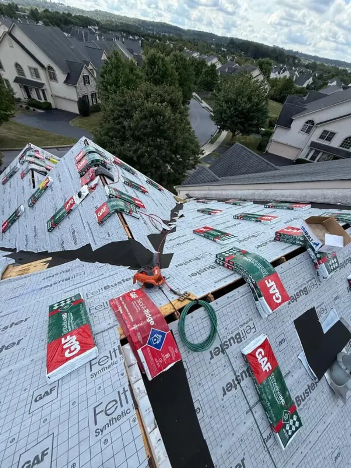 Roof decked out in GAF FeltBuster synthetic underlayment with GAF Timberline shingle bundles staged across the slopes ready to install